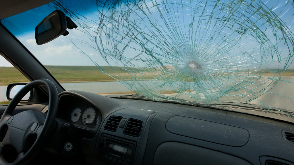 Cracked windshield view from inside the car on a Baltimore road